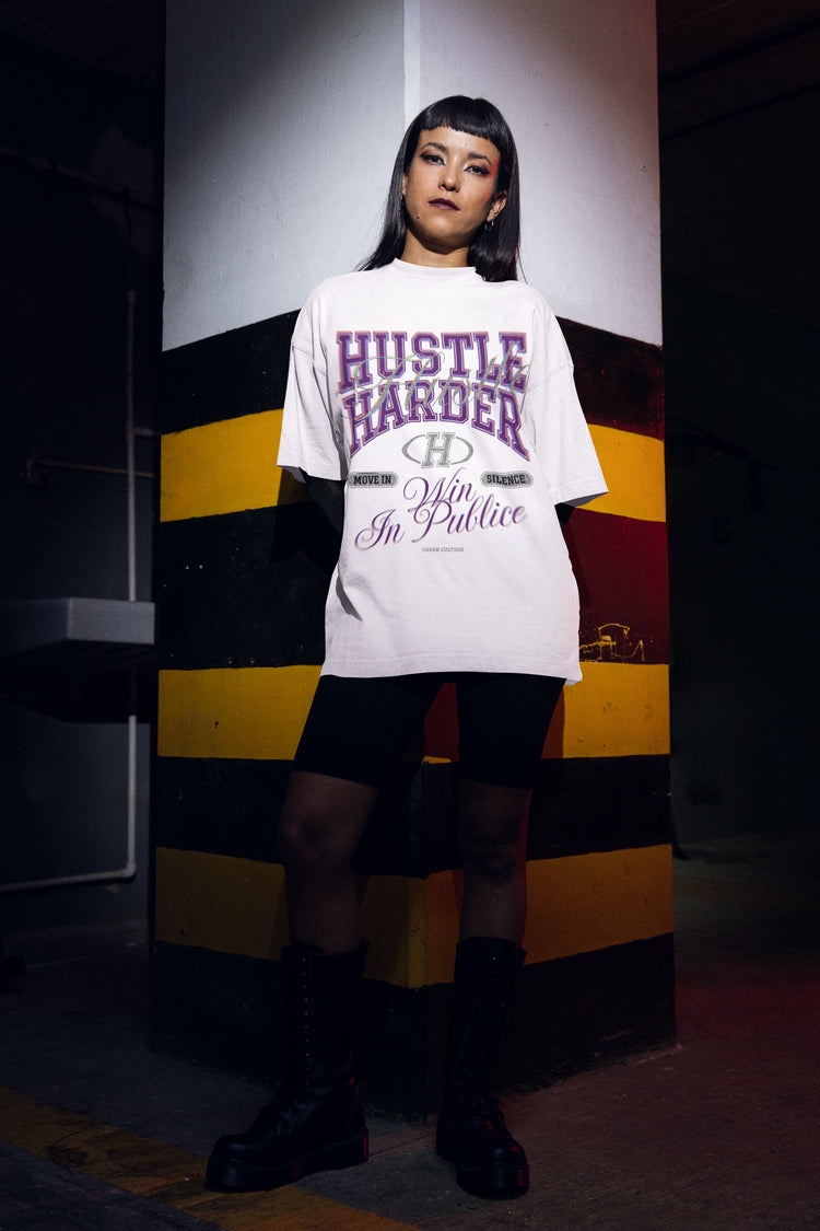 Person wearing a white t-shirt with text in a dark setting