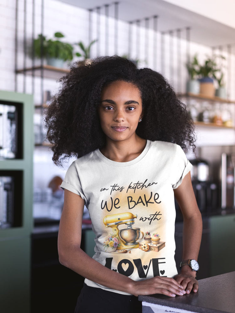 Woman wearing a t-shirt with a bakery-themed design in a kitchen setting
