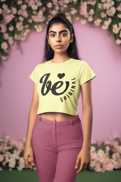 Woman wearing a light yellow t-shirt with text and pink pants against a floral background