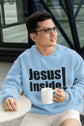 Man wearing a light blue sweatshirt with &