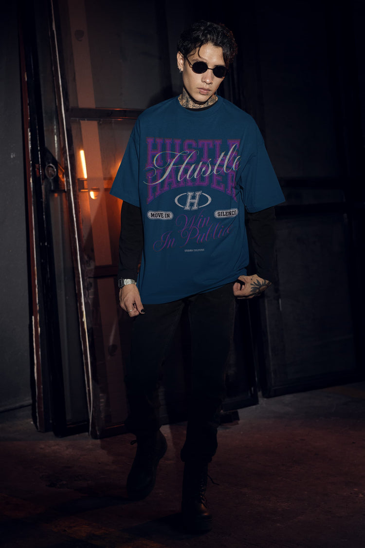 Person wearing a blue t-shirt with text and graphics in a dark setting