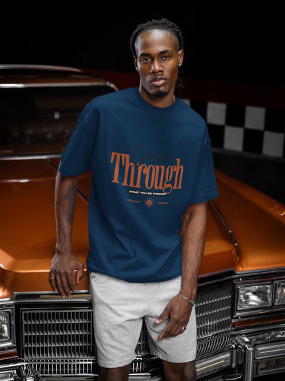 Man wearing a blue t-shirt with 'Through' text standing in front of a vintage car.