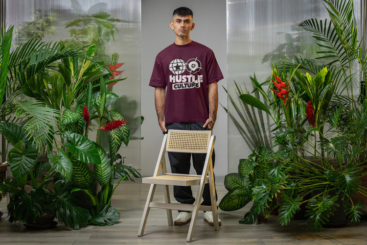 Man standing with a chair in a room with plants