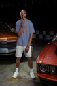 Man standing between two classic cars in a garage