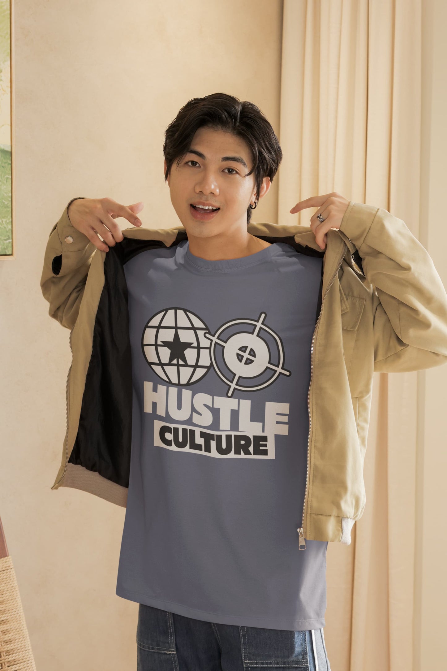 Person wearing a t-shirt with 'Hustle Culture' design, holding a jacket.
