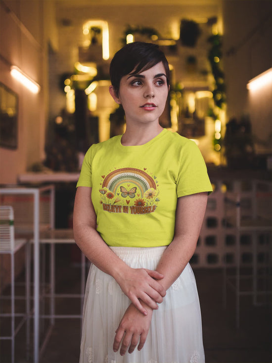 Woman wearing a bright yellow t-shirt with a graphic design in an indoor setting