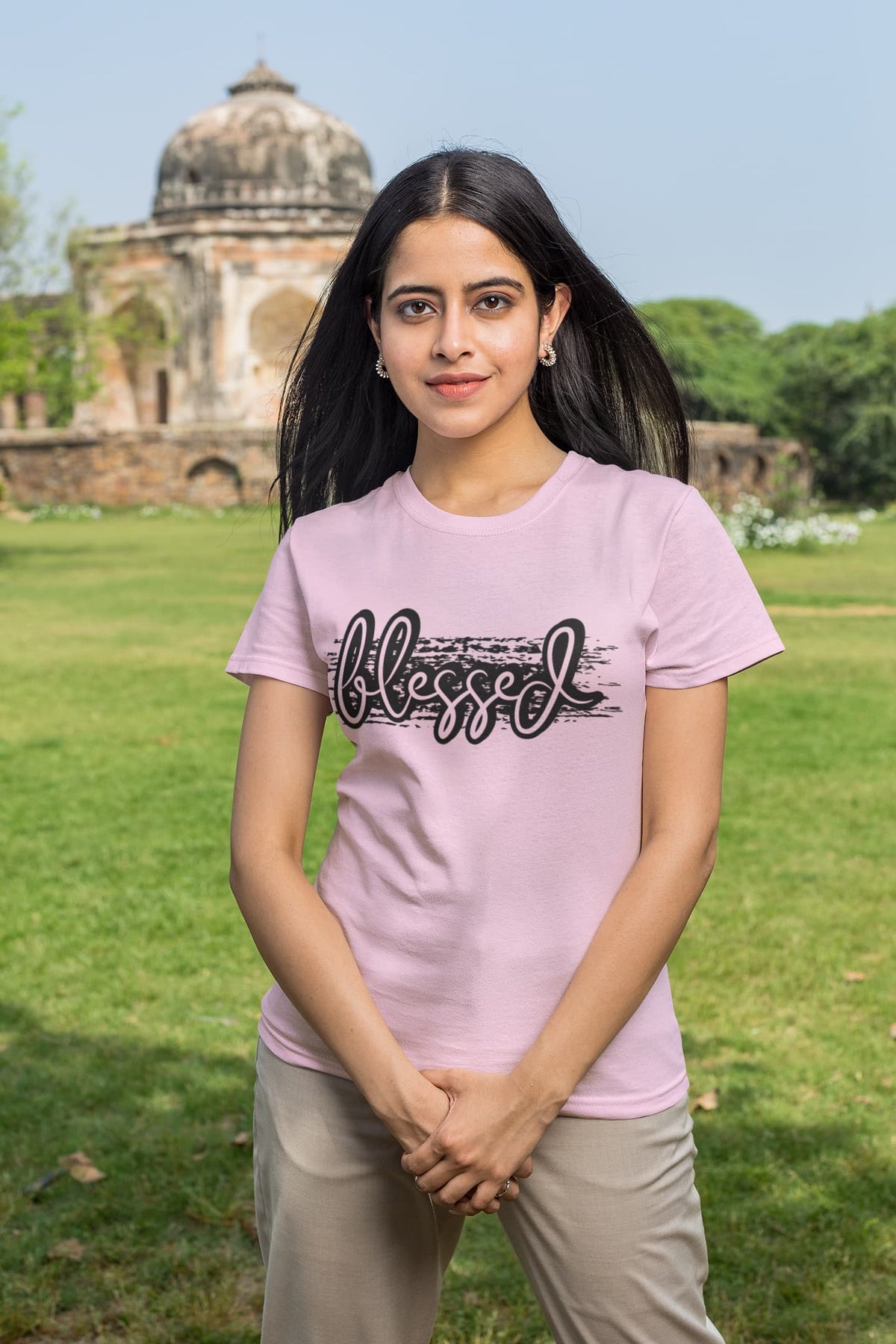 Woman wearing a pink t-shirt with 'blessed' text in an outdoor setting