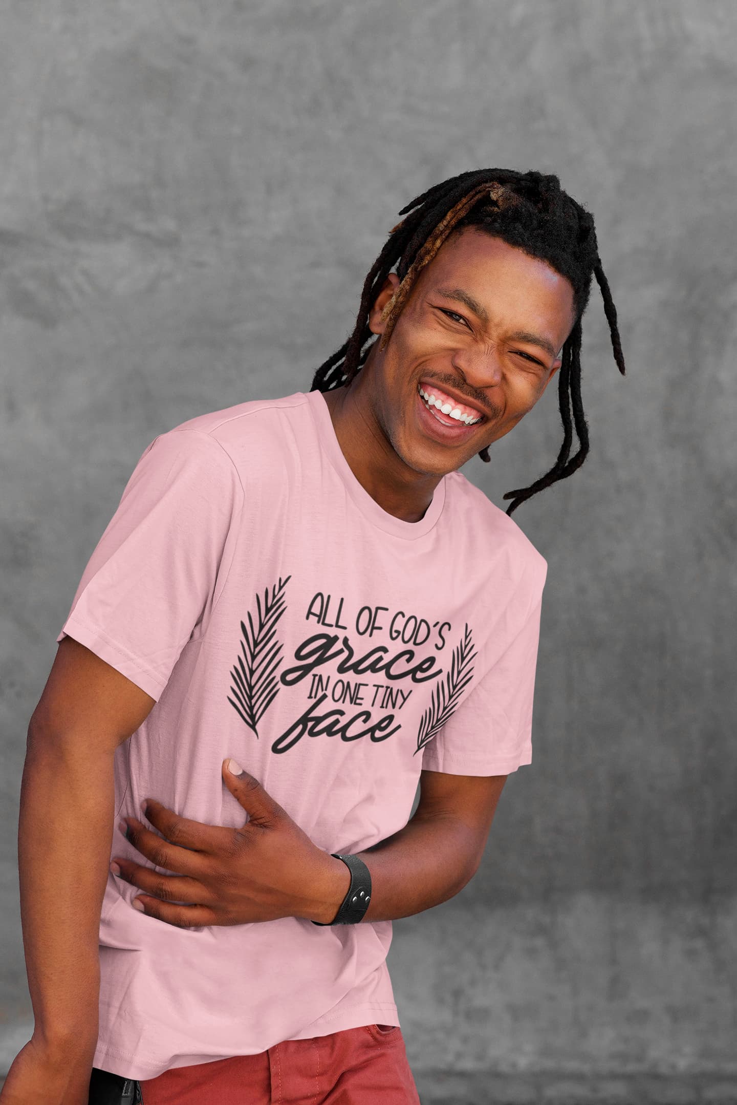 Person wearing a pink t-shirt with text against a gray background