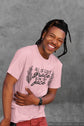 Person wearing a pink t-shirt with text against a gray background