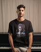 Man wearing a black t-shirt with a graphic design sitting in front of a piano.