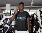 Man wearing a black t-shirt with motivational text in a gym setting