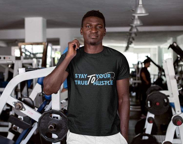 Man wearing a black t-shirt with motivational text in a gym setting