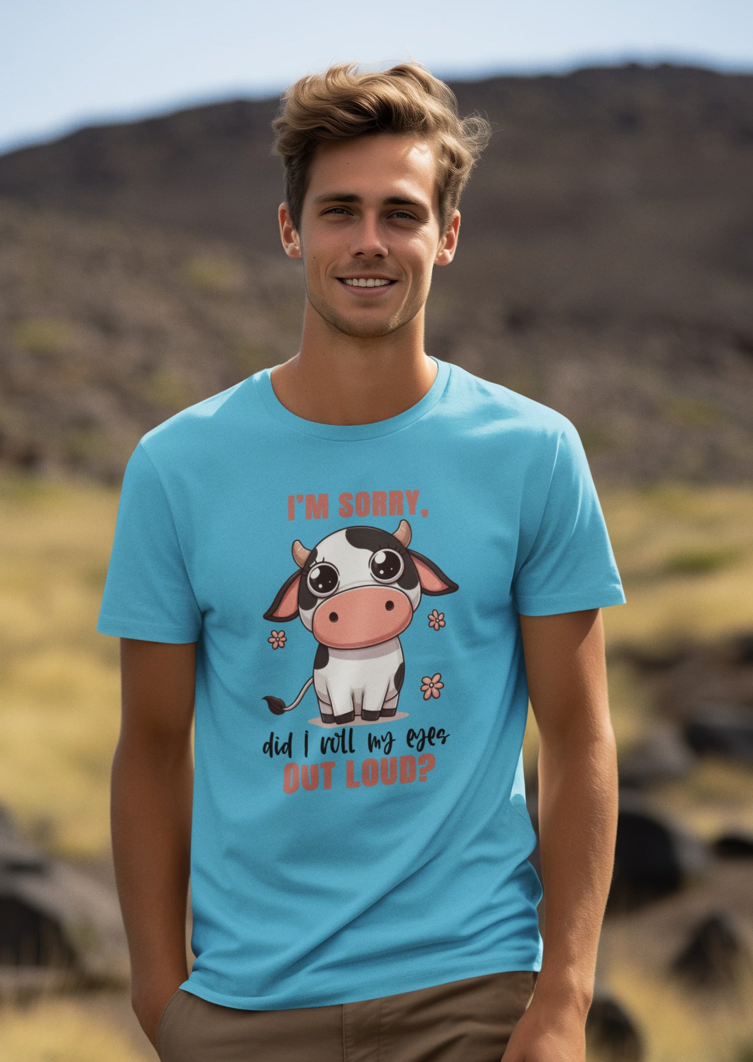 Man wearing a blue t-shirt with a cow graphic and text outdoors.