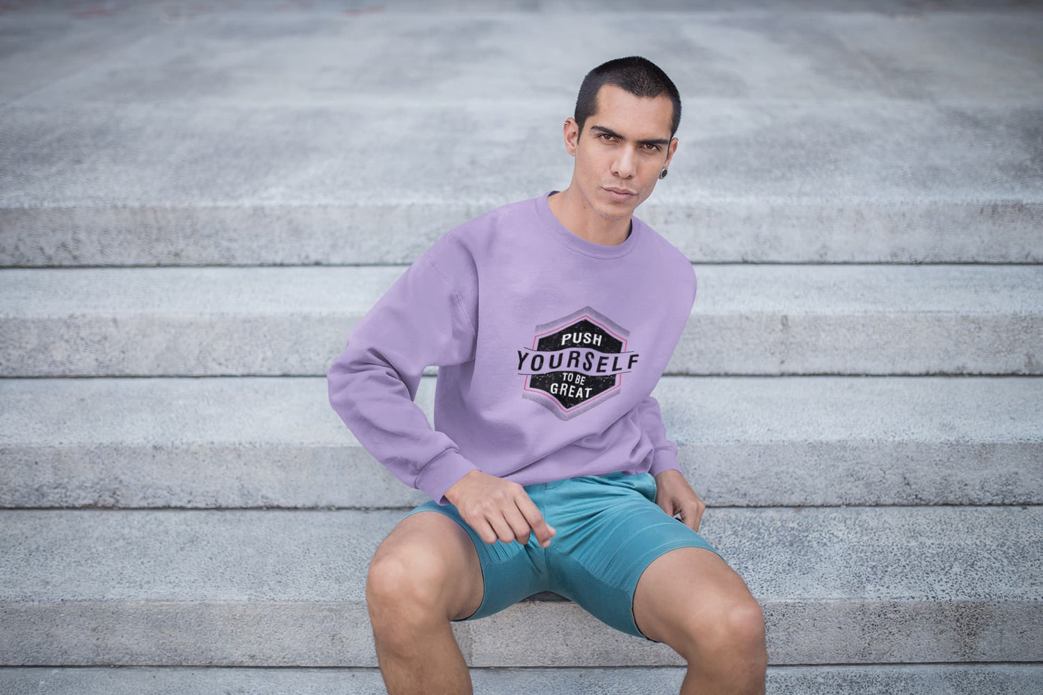 Man wearing a purple sweatshirt with motivational text, sitting on steps.