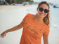 Woman wearing an orange t-shirt with &
