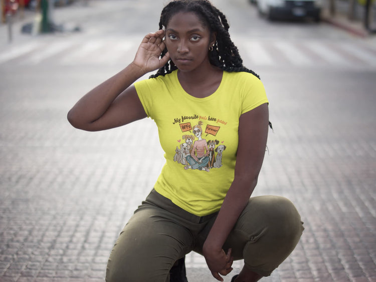 Woman wearing a yellow t-shirt with a graphic design on a city street.