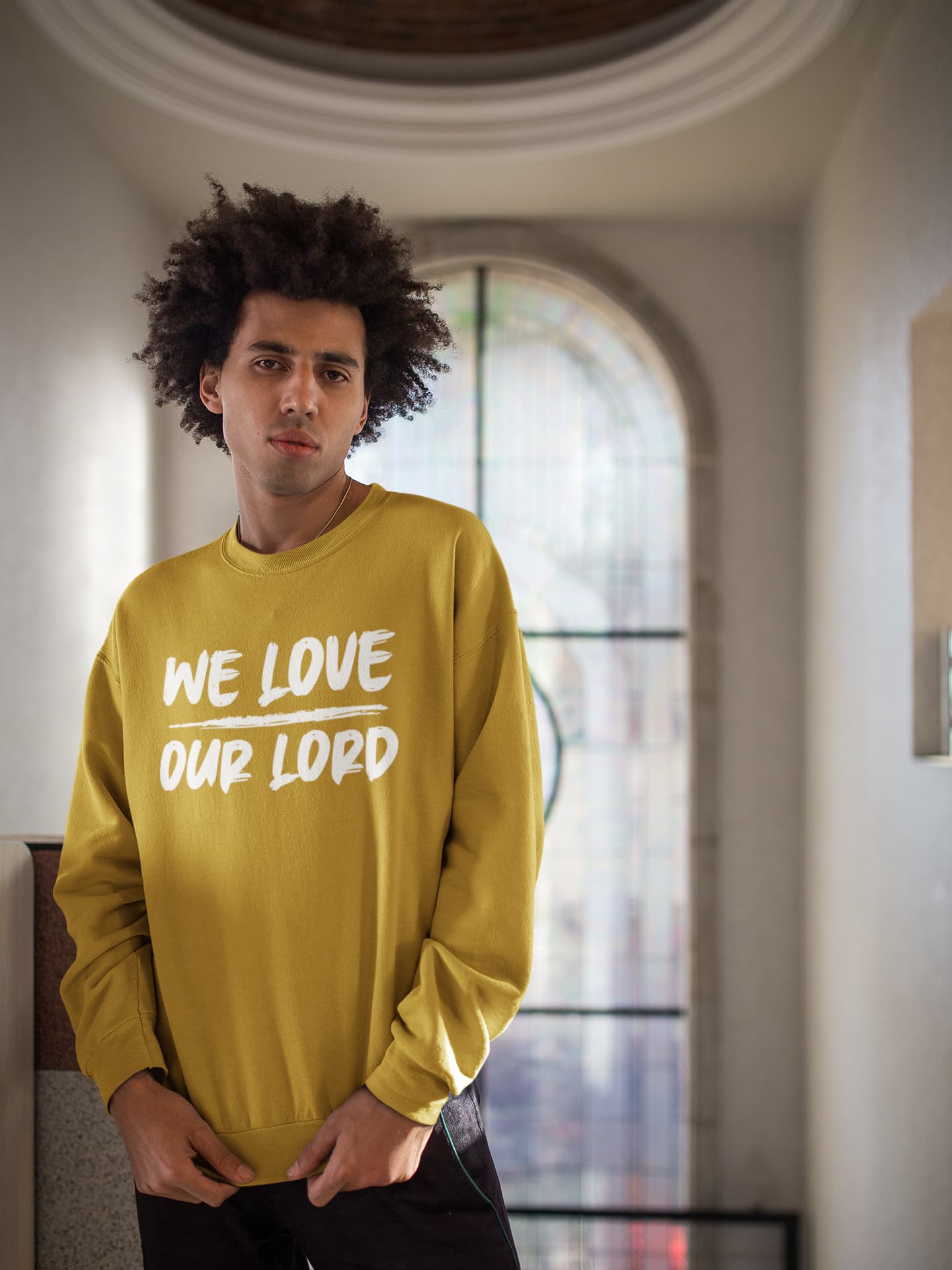 Person wearing a yellow sweatshirt with text in an indoor setting