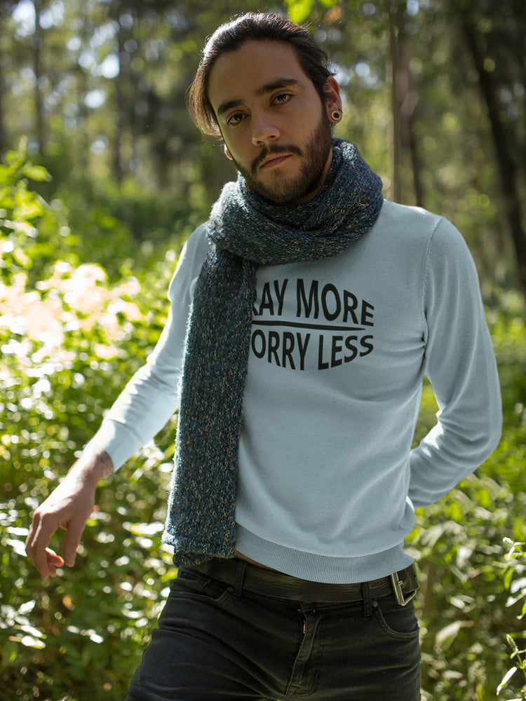 Person wearing a white sweatshirt with text and a blue scarf in a forest setting