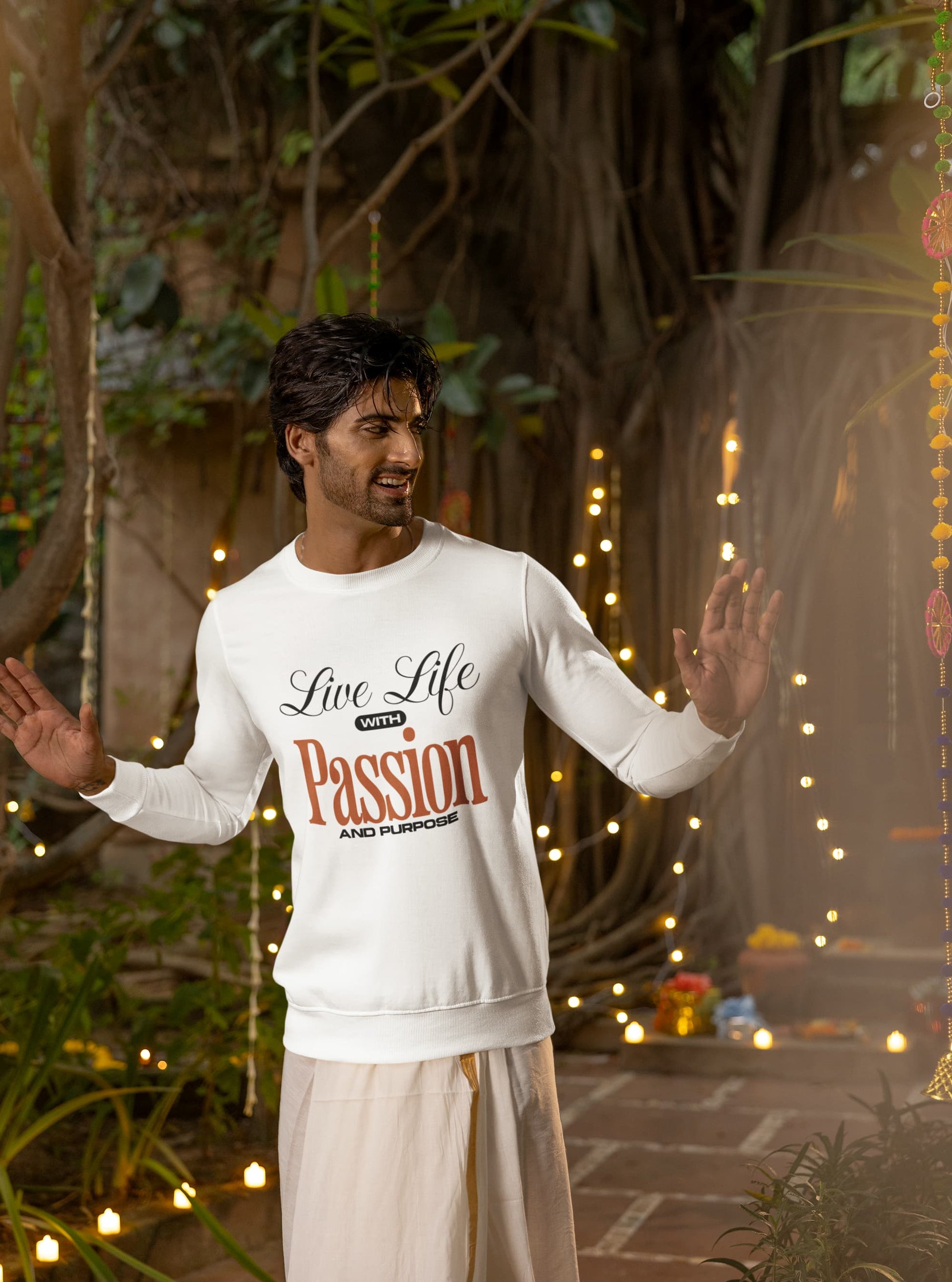 Man wearing a white sweatshirt with 'Live Life with Passion' text in an outdoor setting with lights and plants.