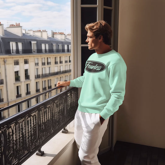 Man wearing a light blue sweatshirt with 'Fearless' text, standing on a balcony with a cityscape view.