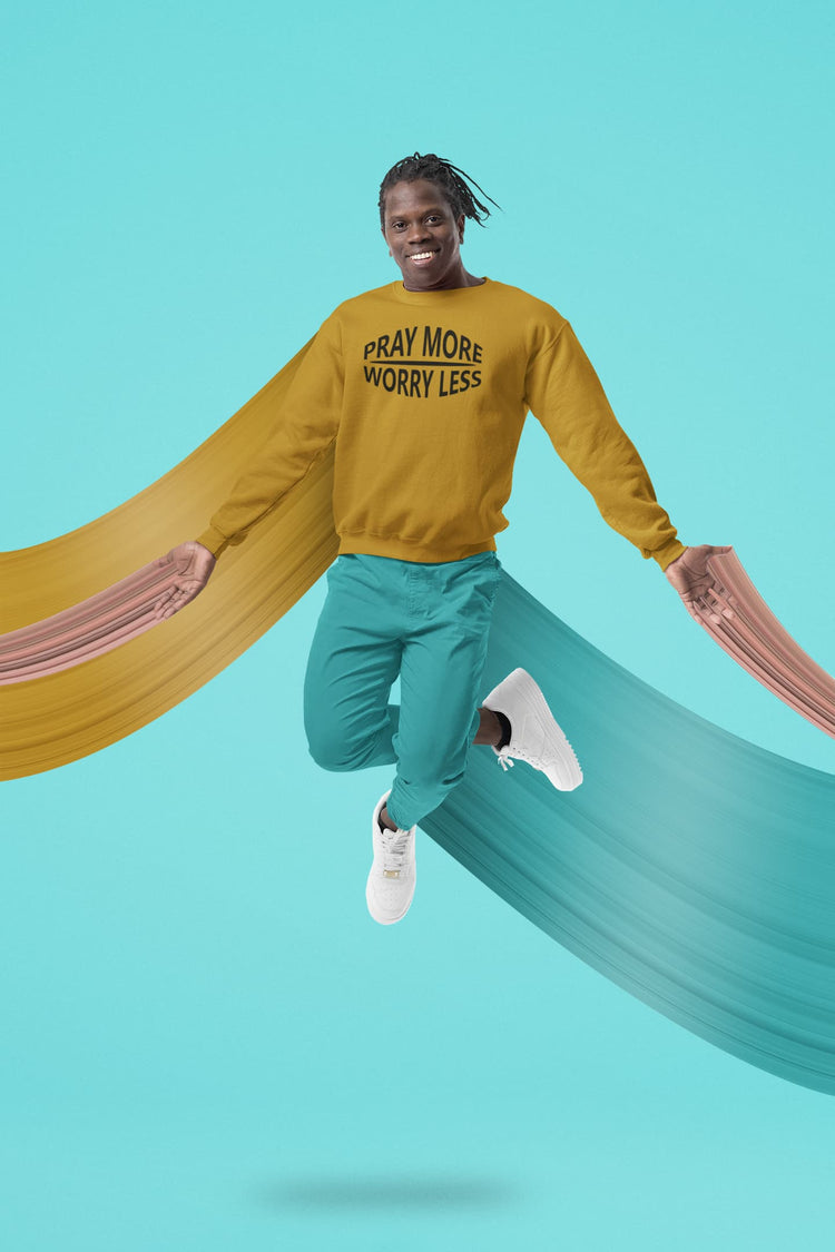 Person wearing a mustard yellow sweatshirt with text, teal pants, and white shoes on a teal background