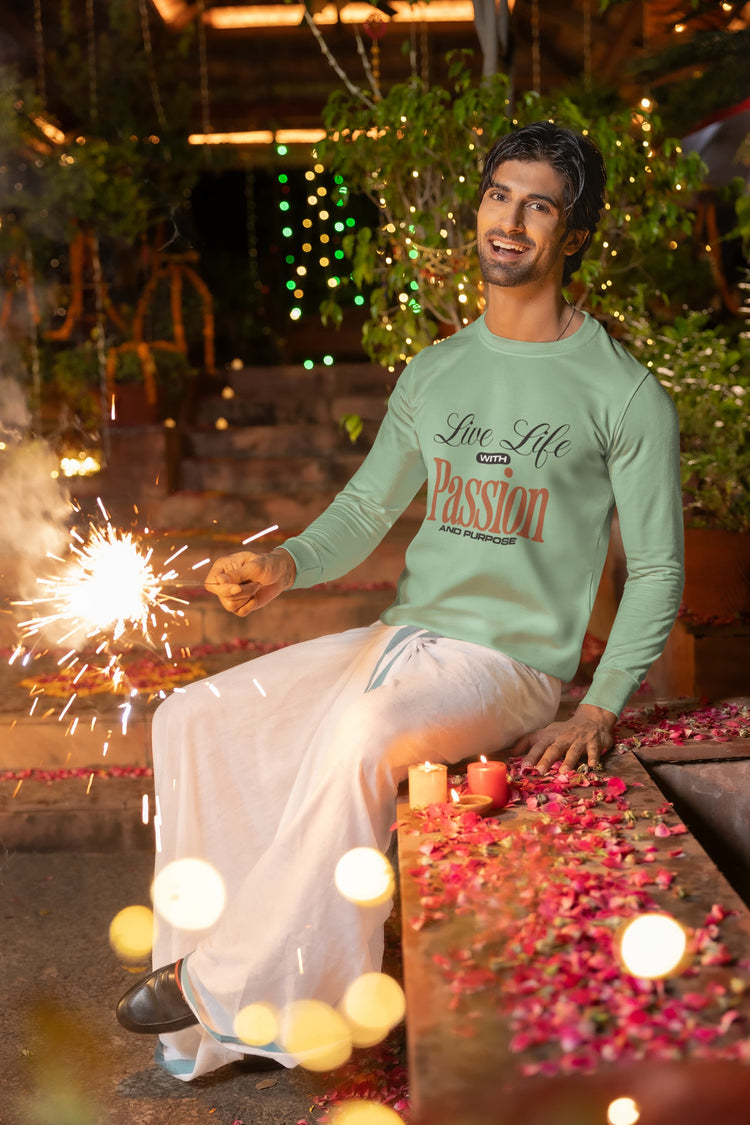 Man wearing a green shirt with text sitting by a poolside with sparklers and candles.