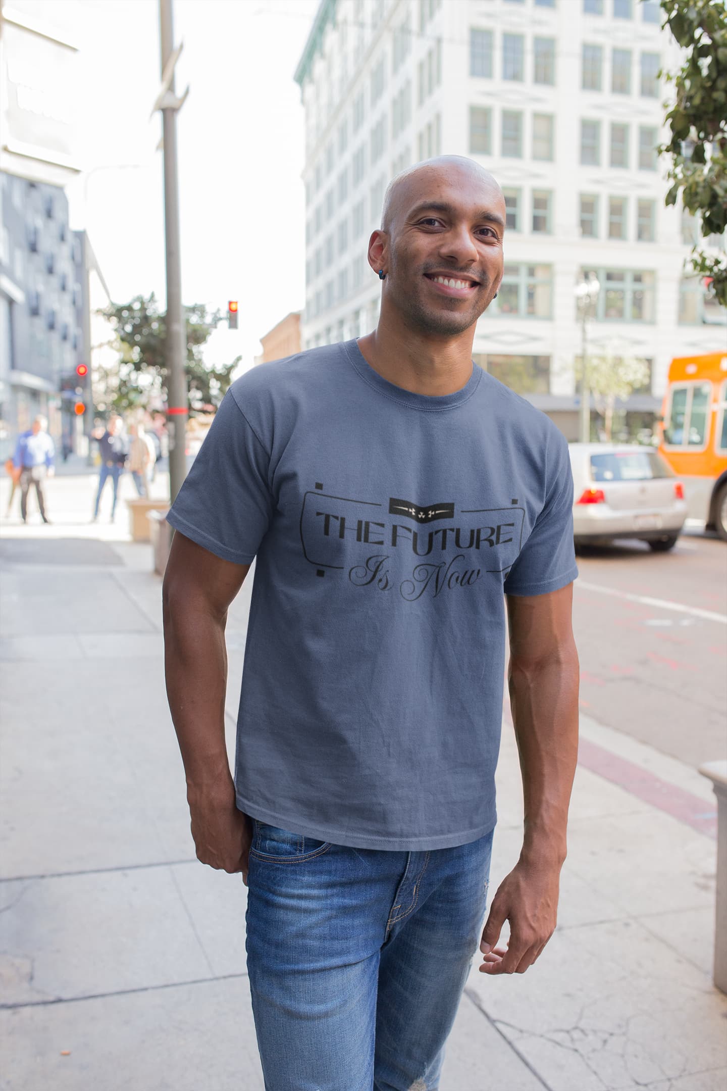 Man wearing a blue t-shirt with text standing on a city street.