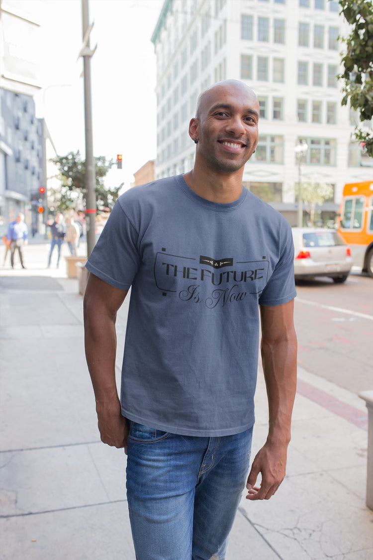 Man wearing a blue t-shirt with text standing on a city street.