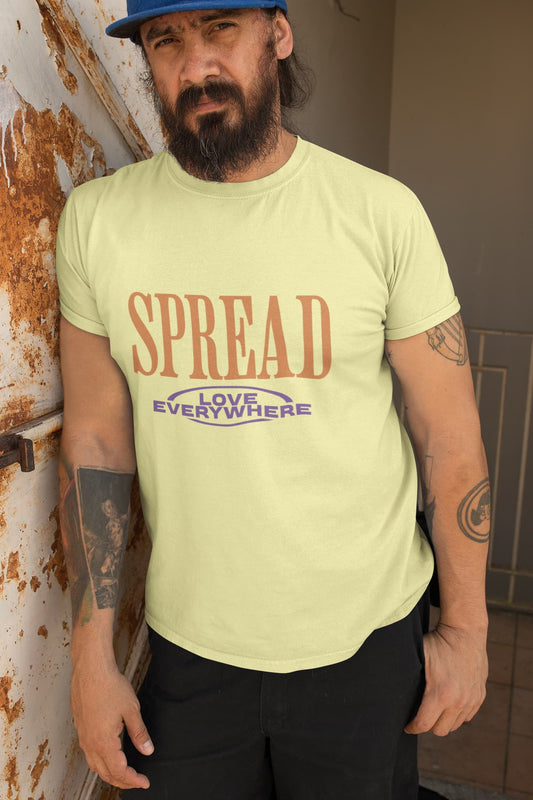 Man wearing a light green t-shirt with 'SPREAD LOVE EVERYWHERE' text, standing against a wall.