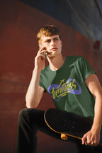 Person wearing a green t-shirt with a logo, holding a skateboard, against a blurred background