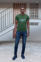 Man wearing a green t-shirt with text standing outdoors.