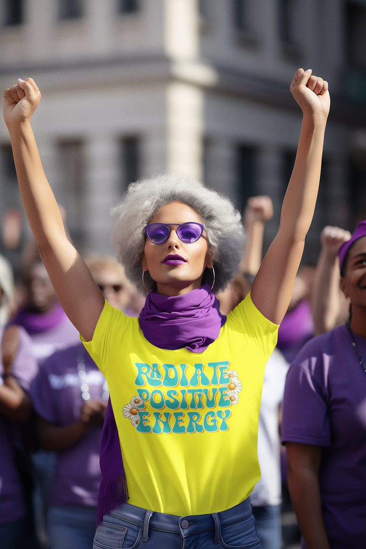 Woman with raised arms wearing a yellow shirt with &