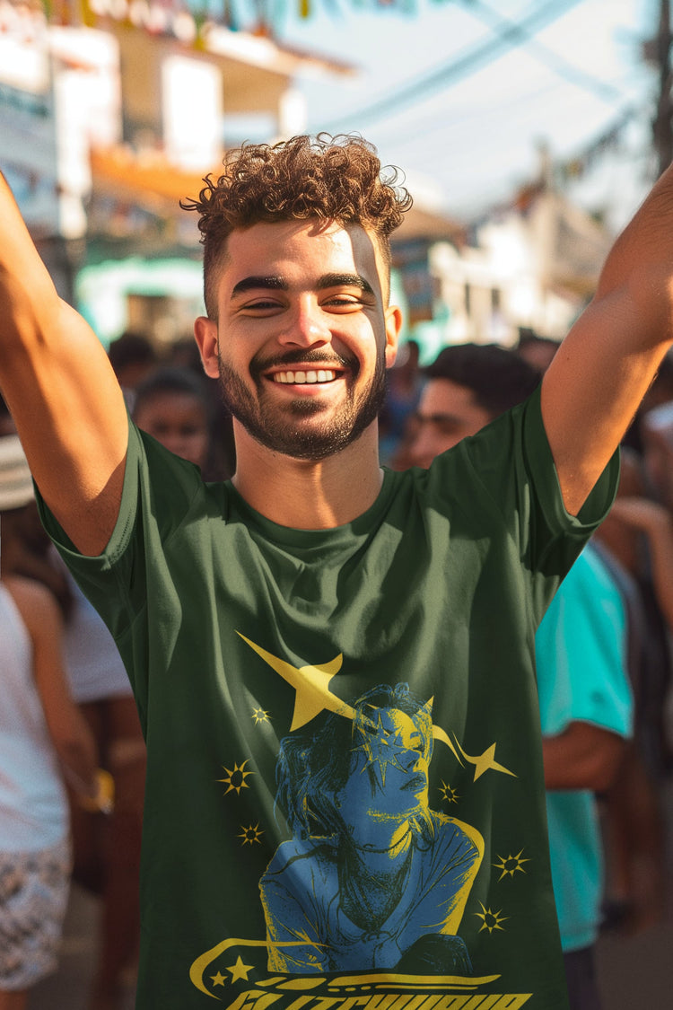 Man wearing a green t-shirt with a graphic design, smiling with arms raised in an outdoor setting.
