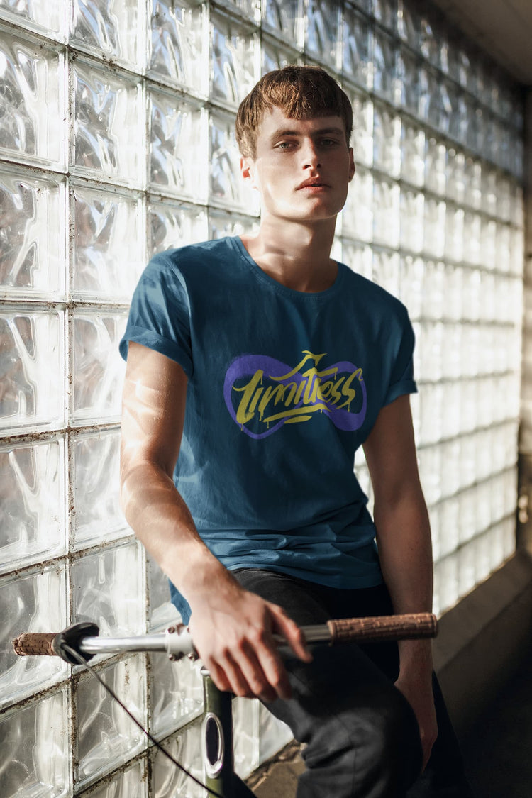 Person wearing a blue t-shirt with a logo, holding a bicycle against a glass block wall.