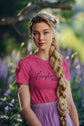 Woman wearing a pink t-shirt with text in a garden setting