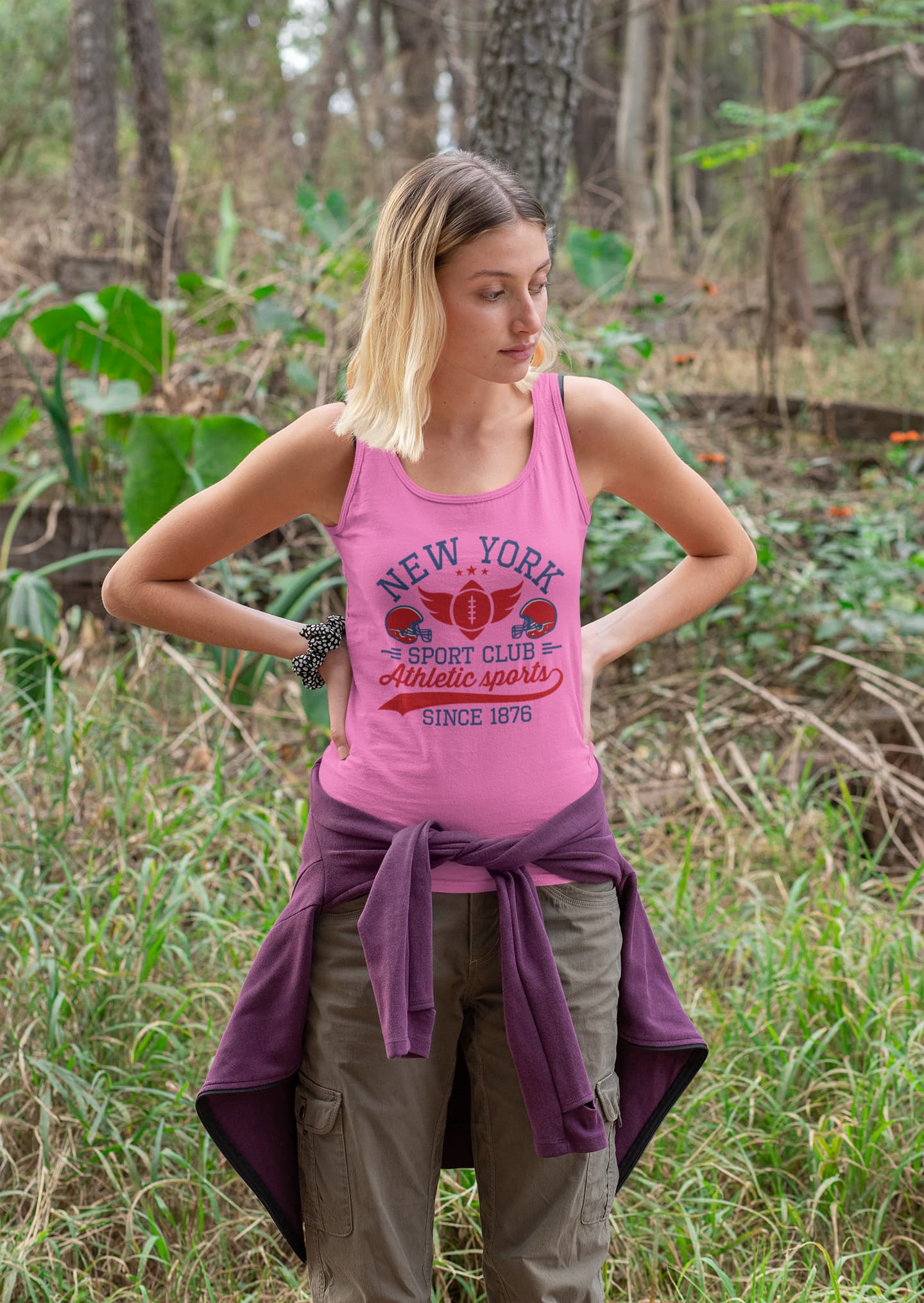 Woman wearing a pink tank top with text in a forest setting