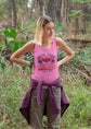 Woman wearing a pink tank top with text in a forest setting