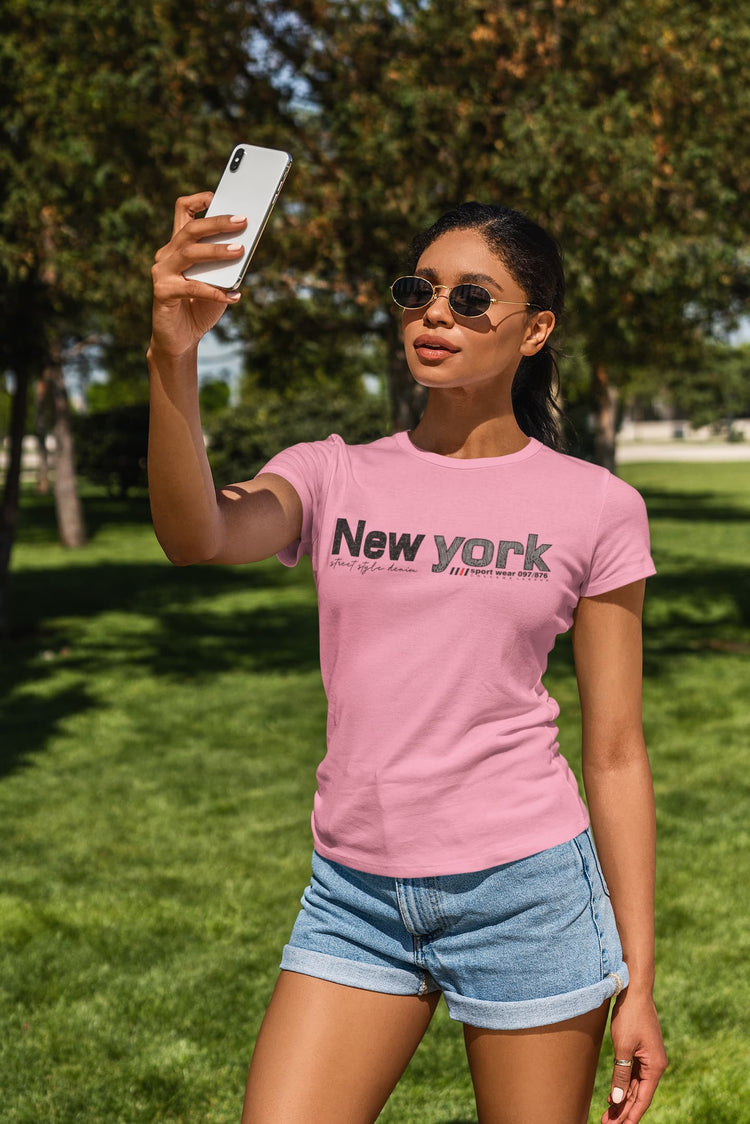 Woman taking a selfie outdoors wearing a pink &